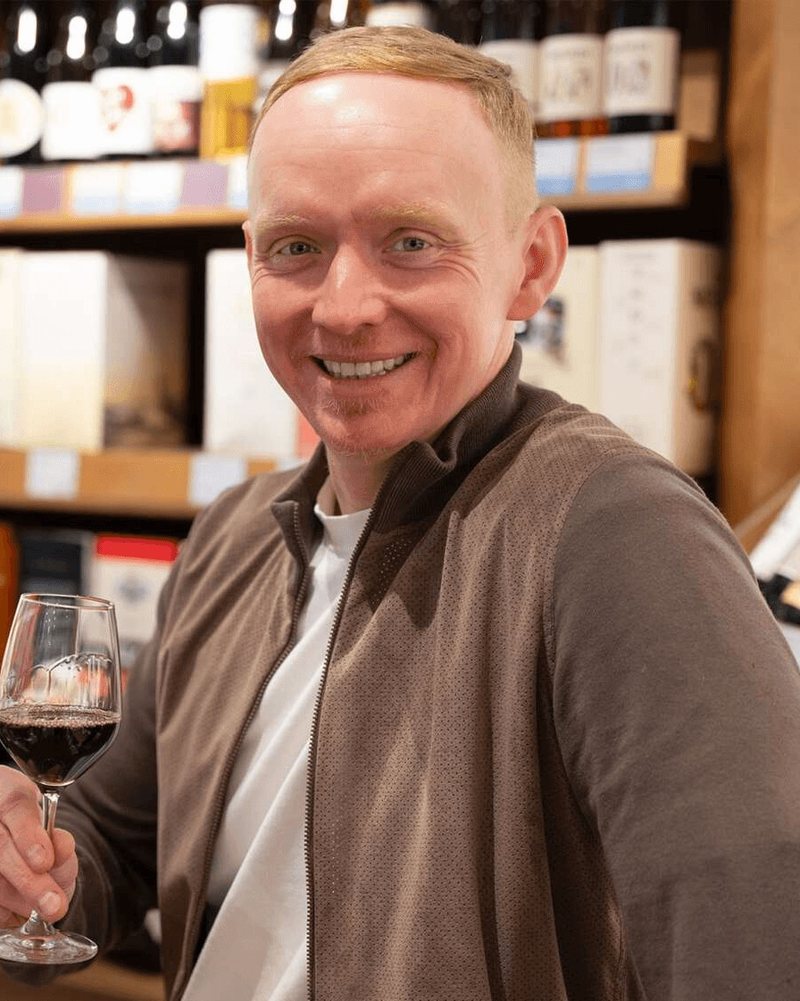 Remigius Szlachetka mit einem Glas Rotwein im Wein-Depot